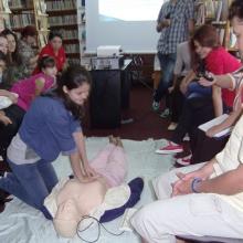 Library trainees practise using the First Aid dummy.