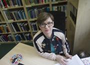 EIFL Copyright Coordinator in Poland, Barbara Szczepańska, sitting at her desk, with bookshelves in the background. 