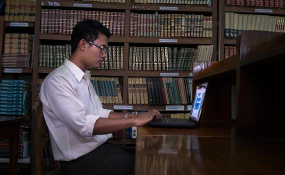Young man studying at the computer in Myanmar library.