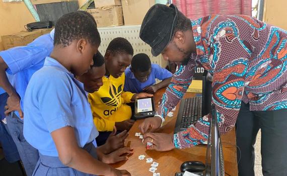 Librarian helping children with coding, using a puzzle. 