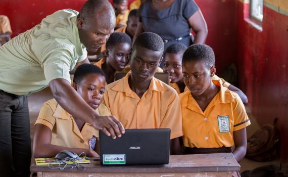 Teacher George Ebo Brown gives children at Archbishop Amissah Junior High School in Western Region their first hands-on computer lesson. Photo by Ryan Yingling. Teacher George Ebo Brown showing children at Archbishop Amissah Junior High School in Western Region how to use a laptop computer. Photo by Ryan Yingling.